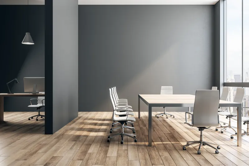 a room with a table, chairs and a laptop