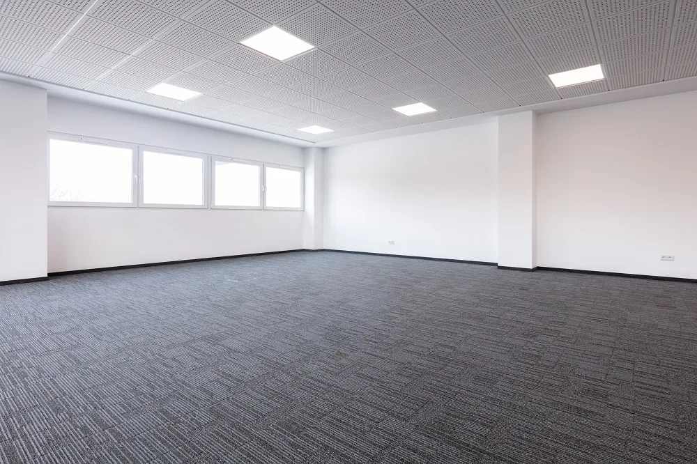 an empty room with a gray carpet and white walls